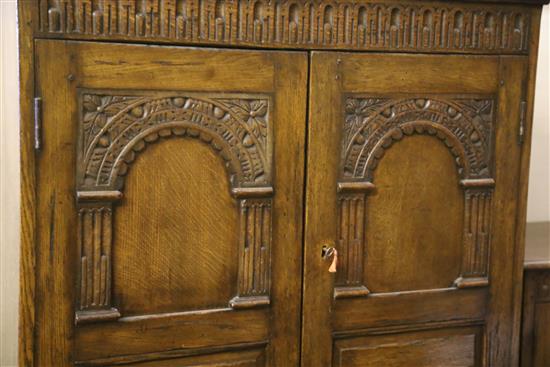 A carved and panelled oak wardrobe fitted two doors with matching compactum and dressing table, wardrobe W.104cm, D.55cm, H.178cm